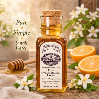 Orange Blossom Honey bottle displayed with fresh citrus, orange blossoms, honey dipper, and bright farmhouse kitchen styling.