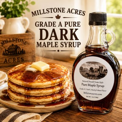 Millstone Acres Pure Dark Maple Syrup Grade A, bottle displayed beside hot pancakes topped with melting butter and rich dark maple syrup in a farmhouse kitchen.